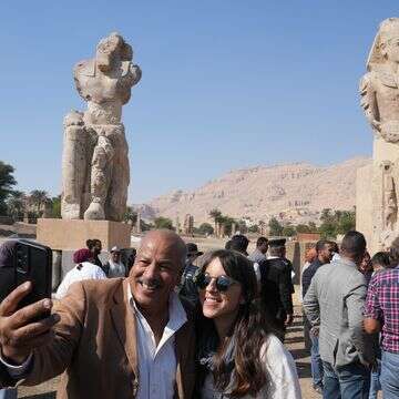 מבקרים מצטלמים עם שני פסלי בהט ענקיים שהורכבו מחדש של פרעה אמנחותפ השלישי, בעיר לוקסור שבדרום מצרים | AP Photo/Amr Nabil מבקרים מצטלמים עם שני פסלי בהט ענקיים שהורכבו מחדש של פרעה אמנחותפ השלישי, בעיר לוקסור שבדרום מצרים | AP Photo/Amr Nabil