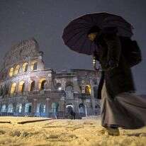 גבר חולף על פני הקולוסיאום ברומא המושלגת. | AP
