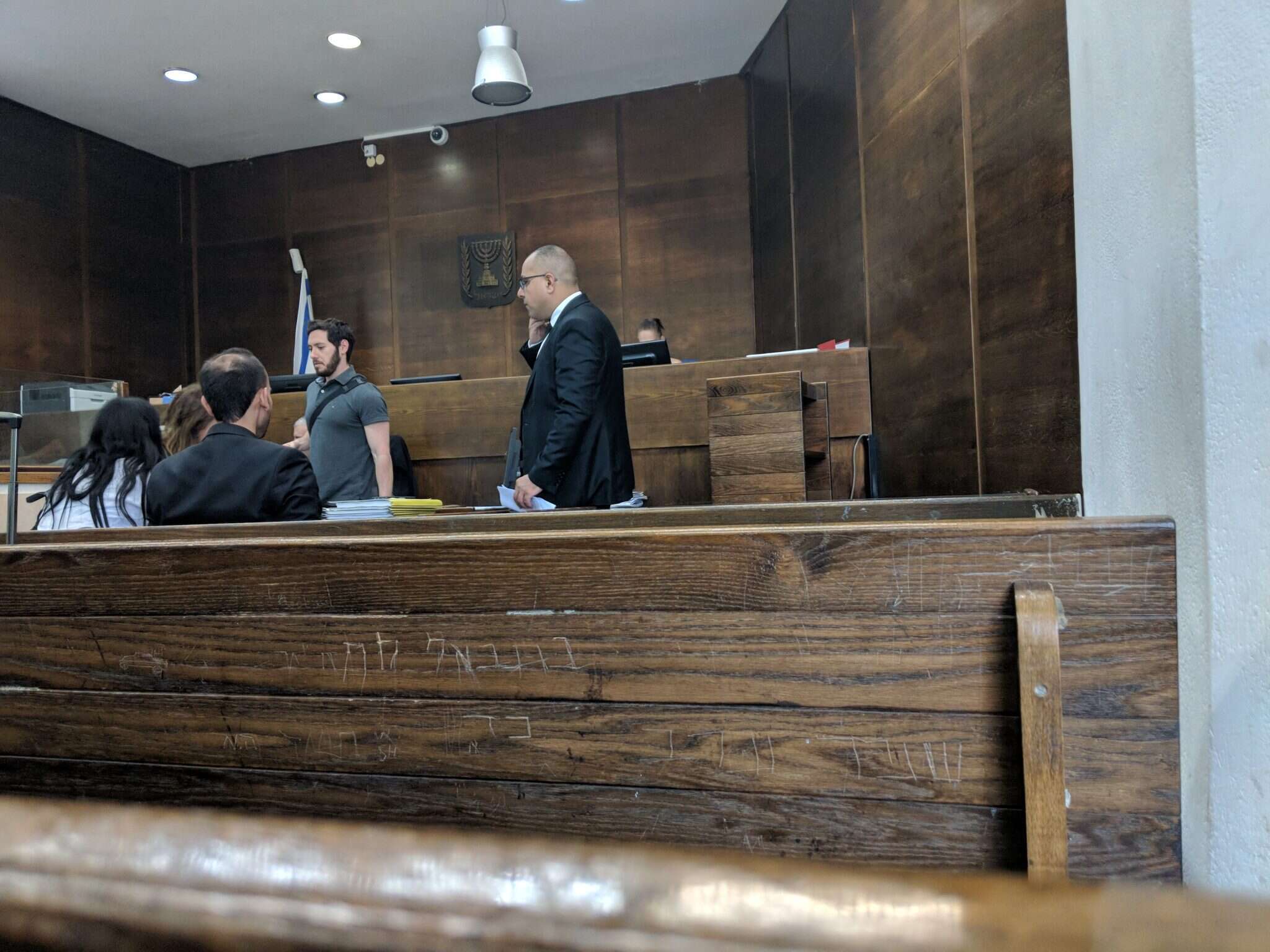 סנגורים וטועני המשטרה ממתינים באולם לכניסת השופטת. | יש פלג