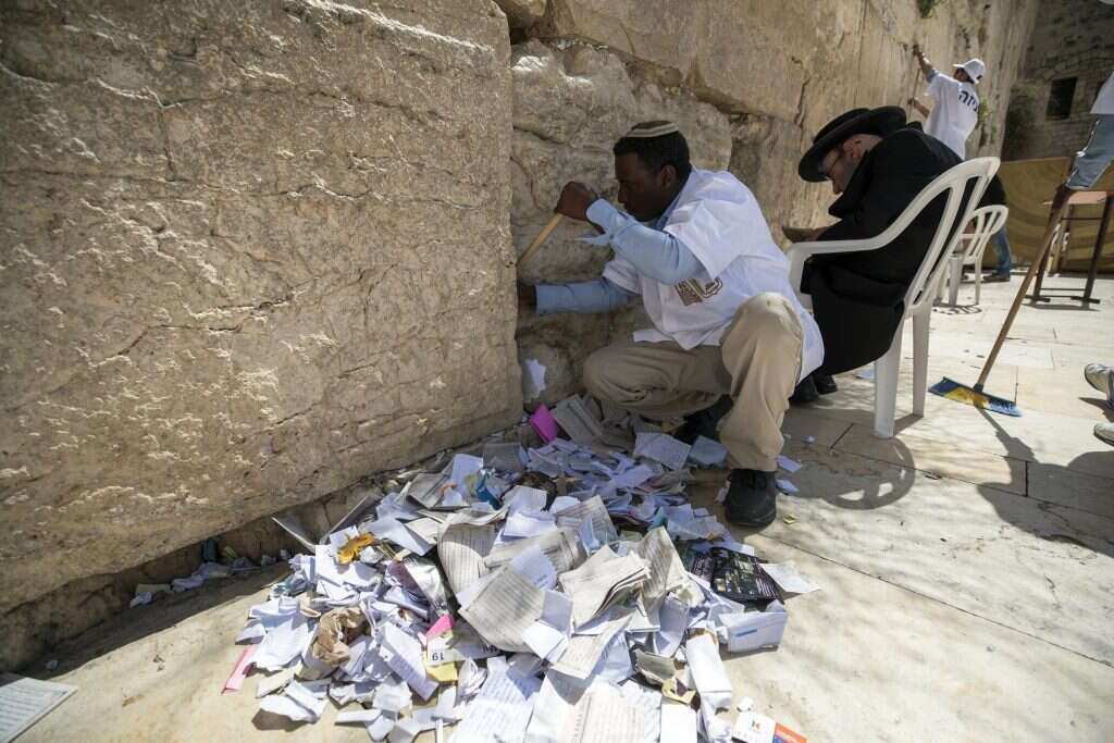 כחלק מההיערכות לקראת חג הפסח, מוציאים את הפתקים שהוטמנו בין אבני הכותל המערבי במהלך השנה. את הפתקים, אגב, קוברים יחד עם ספרי קודש שנשלחו לגניזה. | EPA