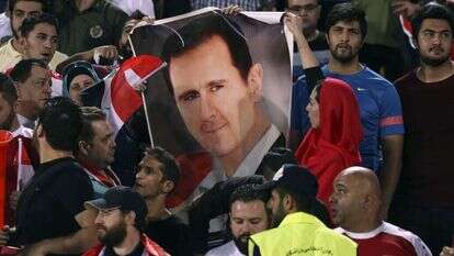 אוהדים סורים עם כרזה שנושאת את דמותו של אסד. | AP