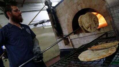 לכבוד ליל הסדר: הכנת מצות שמורות לפסח במאפייה בכפר חב"ד. | AFP