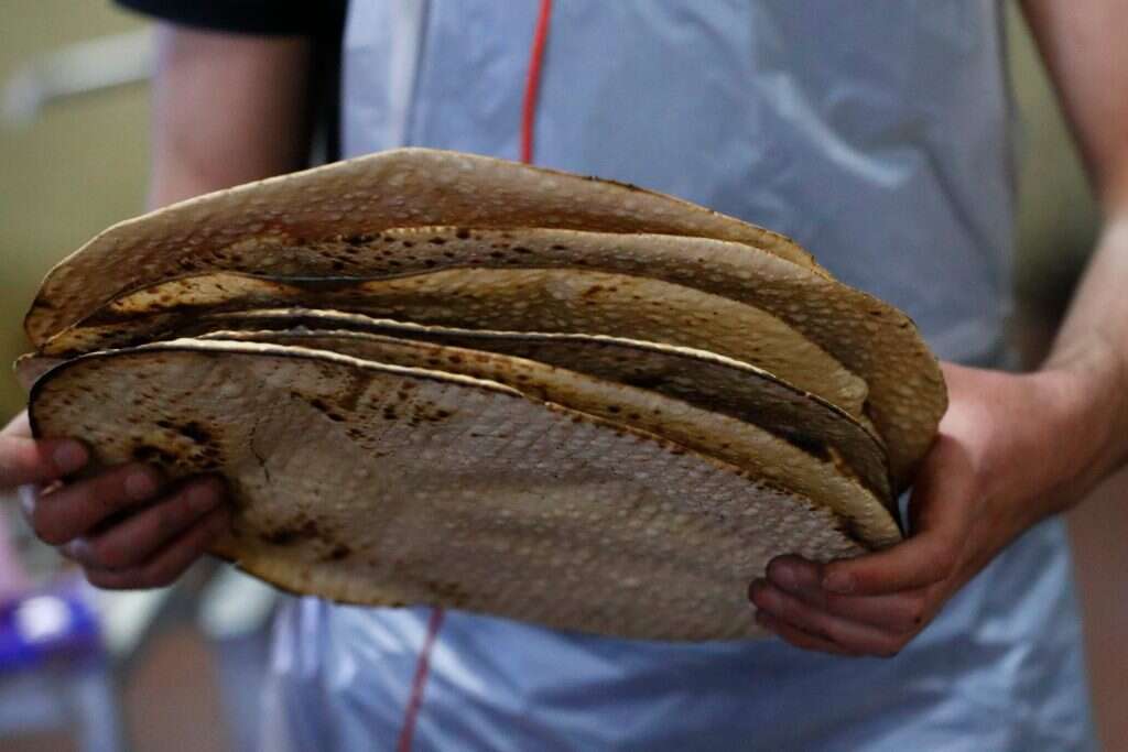 הכנת מצות שמורות לפסח במאפייה בכפר חב"ד. | AFP