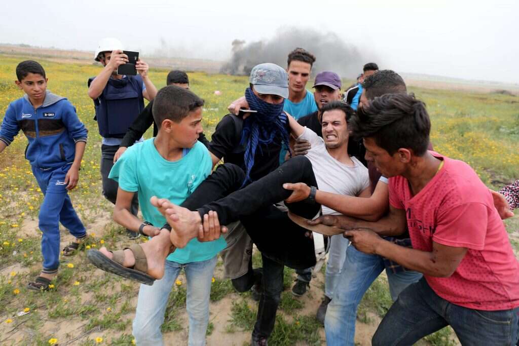 פלסטינים בהפגנה על גדר המערכת בגבול עזה. | AFP
