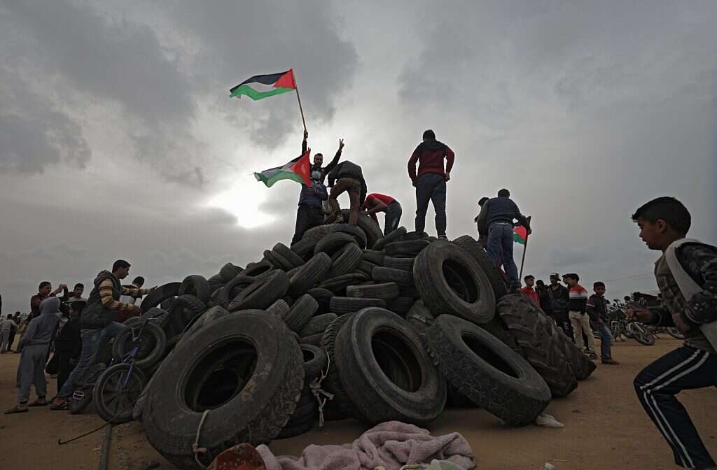 פלסטינים מכינים צמיגים לקראת הצעדה ביום שישי. | EPA