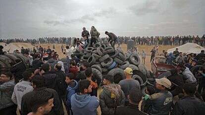 פלסטינים אוספים צמיגים בגבול עזה. | EPA