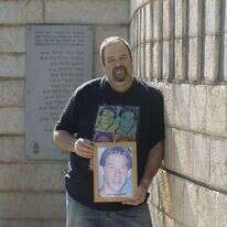 יוסי צור עם תמונת בנו אסף ז"ל. | מישל דוט קום