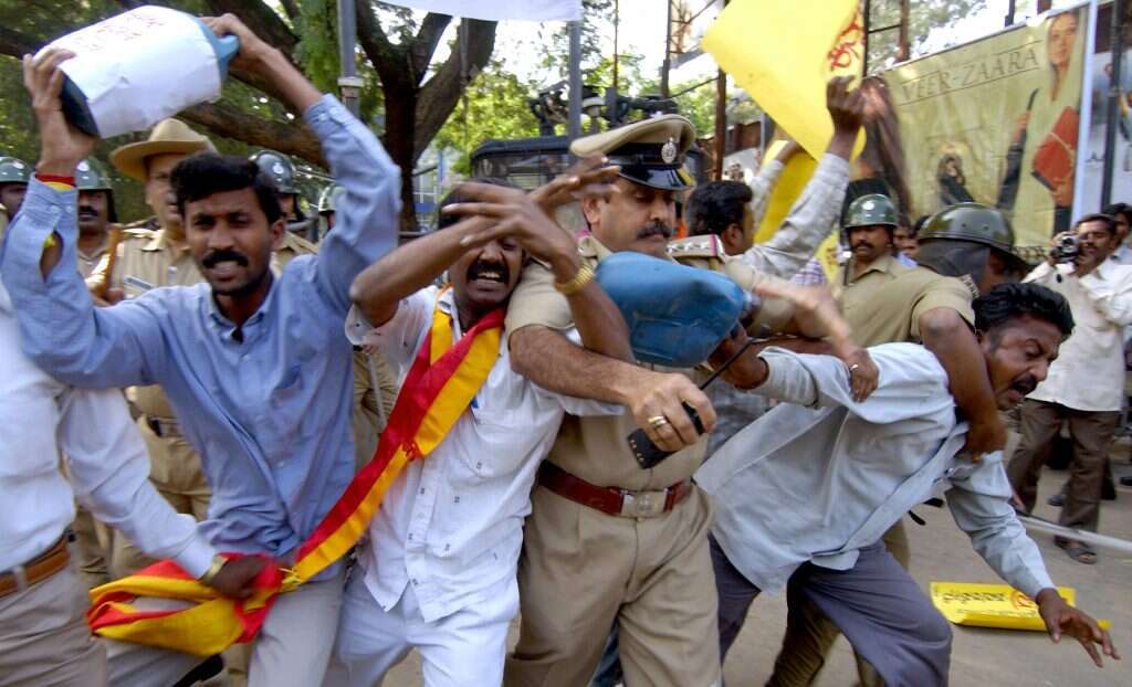 מפגינים בבנגלור מנסים להצית את עצמם במחאה על ניסיונות הקולנוע מבוליווד להשתלט על התרבות הדרום־הודית, 2004. | AFP