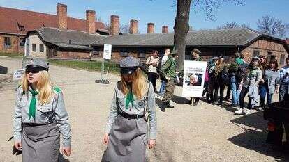 נערים מתנועת הצופים הפולנית מניפים כרזה עם תמונתה של אירנה סנדלר במחנה הריכוז אושוויץ. 2018. | שמואל פאוסט