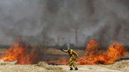 לוחם אש מכבה שריפה בשדה חיטה באזור עוטף עזה. | EPA
