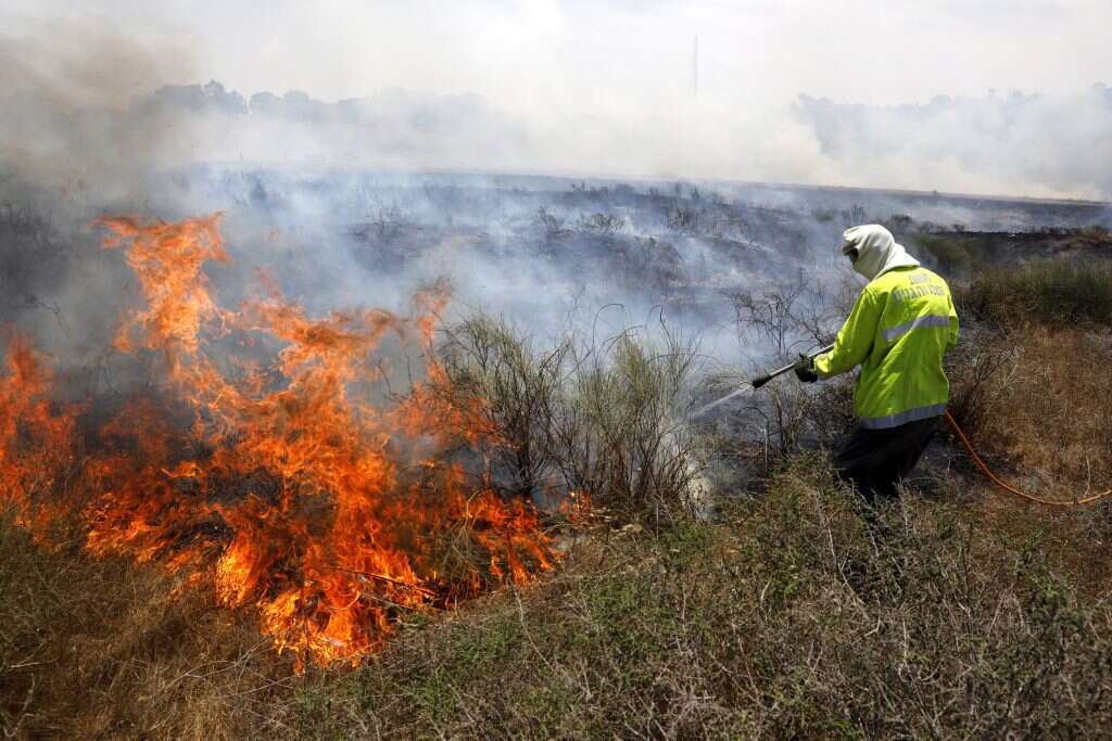 לוחם אש מכבה שריפה בעוטף עזה. | EPA