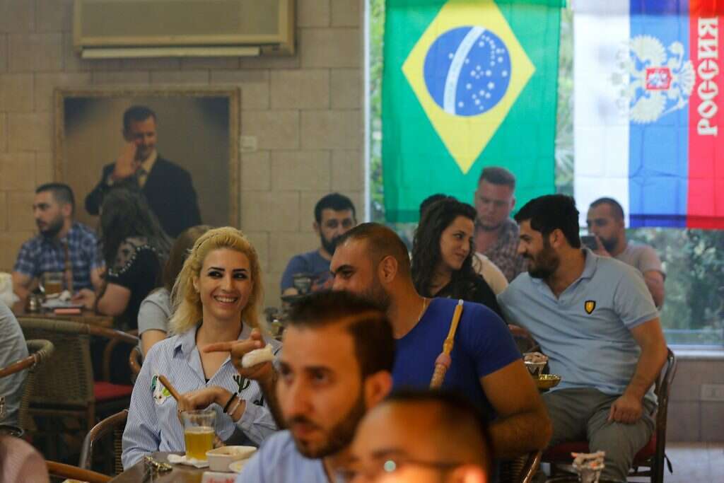 חובבי כדורגל צופים במשחק הפתיחה של המונדיאל בבר בלטקיה. | AFP