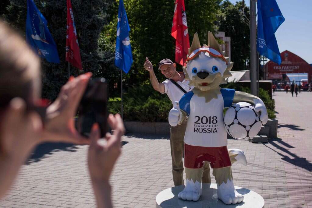 אוהדים מצטלמים עם זביווקה הקמע של המונדיאל. | AFP