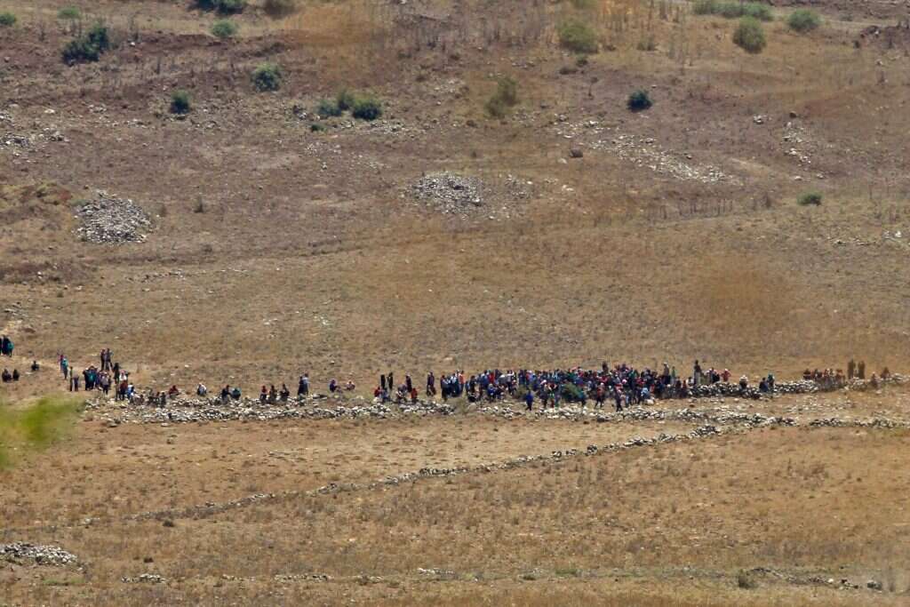 אזרחים סורים בסמוך לגדר הגבול עם ישראל. | AFP אזרחים סורים בסמוך לגדר הגבול עם ישראל. | AFP