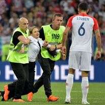 המאבטחים גוררים את חברת הלהקה מחוץ למגרש. לוברן מתצפת. | EPA