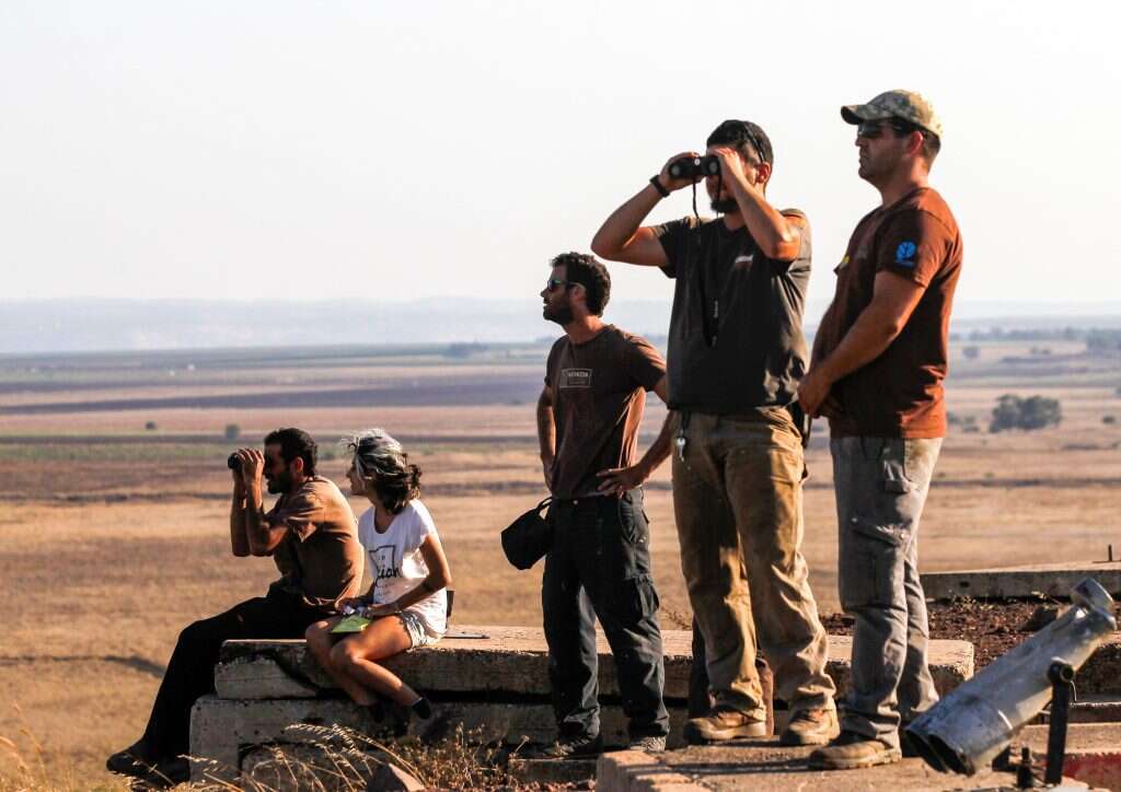 ישראלים סקרנים מתצפתים על הקרבות הניטשים בדרום סוריה. | AFP