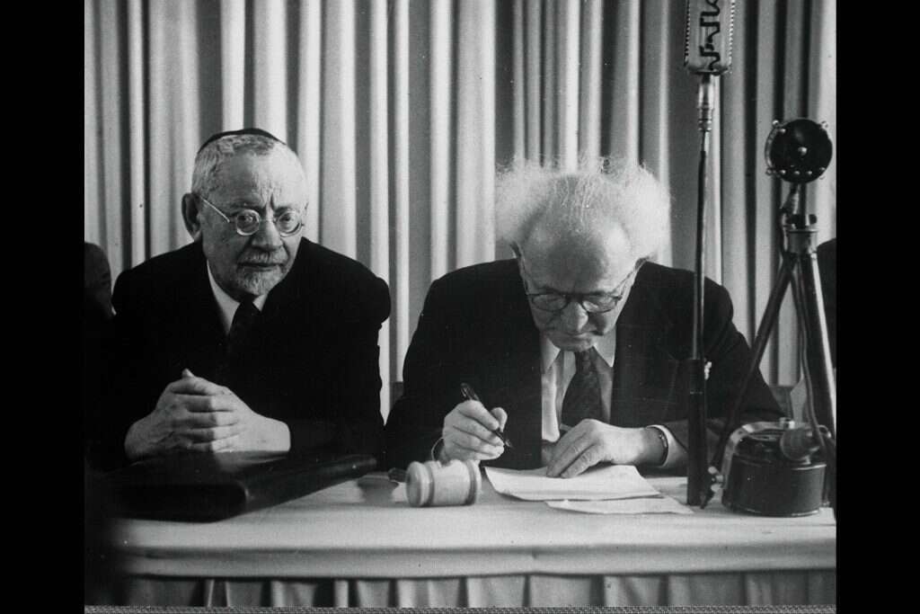 דוד בן גוריון חותם על מגילת העצמאות. | האנס פין, לע''מ