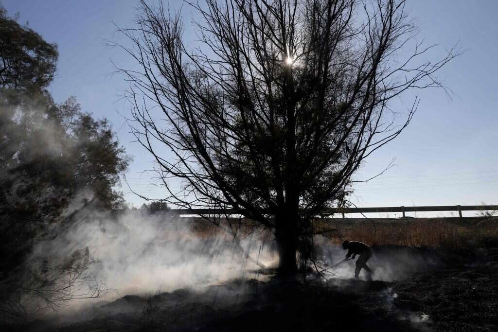 חייל מכבה שרפה בעוטף עזה. | AFP