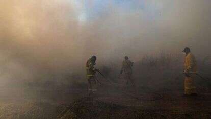 חייל מכבה שרפה בעוטף עזה. | AFP