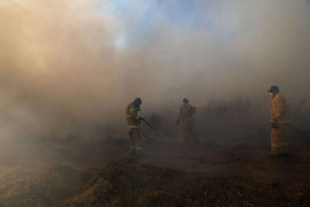חייל מכבה שרפה בעוטף עזה. | AFP