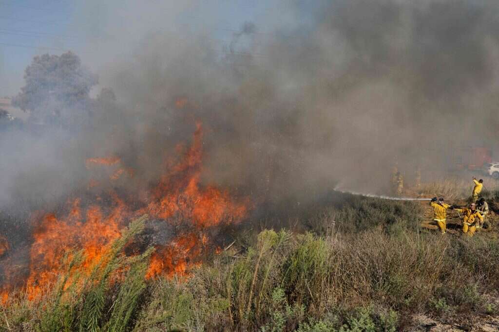 חייל מכבה שרפה בעוטף עזה. | AFP