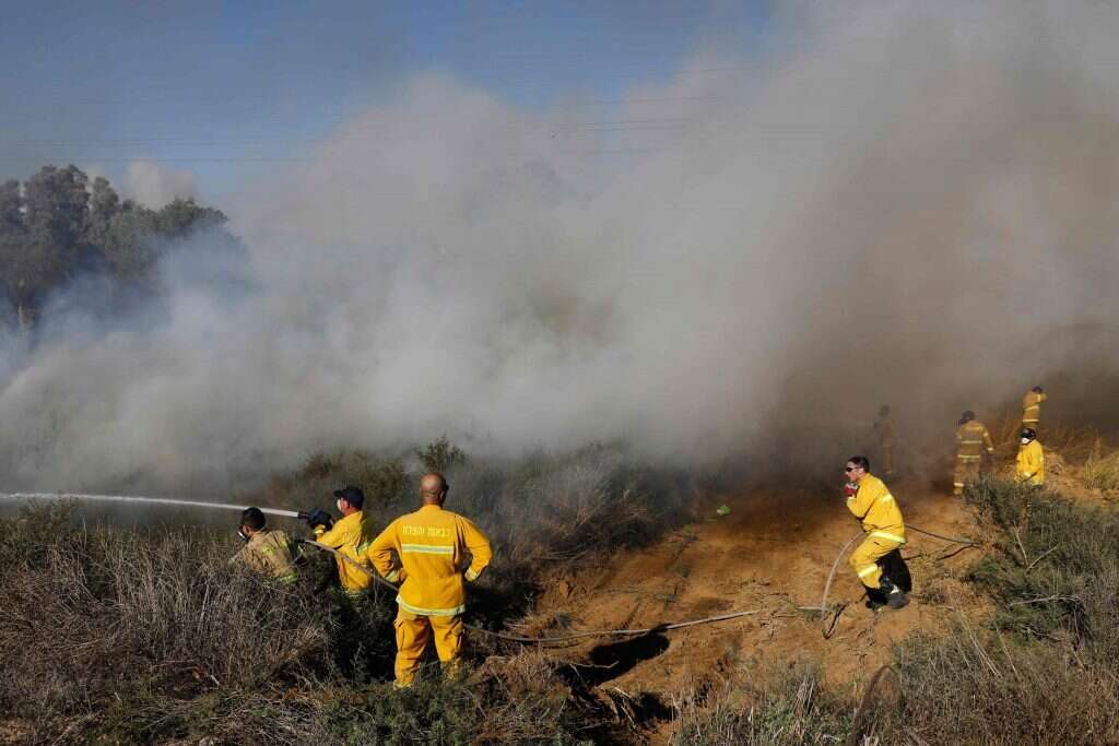 חייל מכבה שרפה בעוטף עזה. | AFP