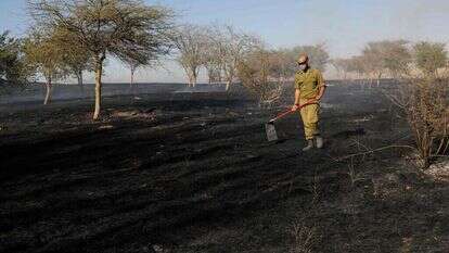 חייל מכבה שרפה בעוטף עזה. | AFP