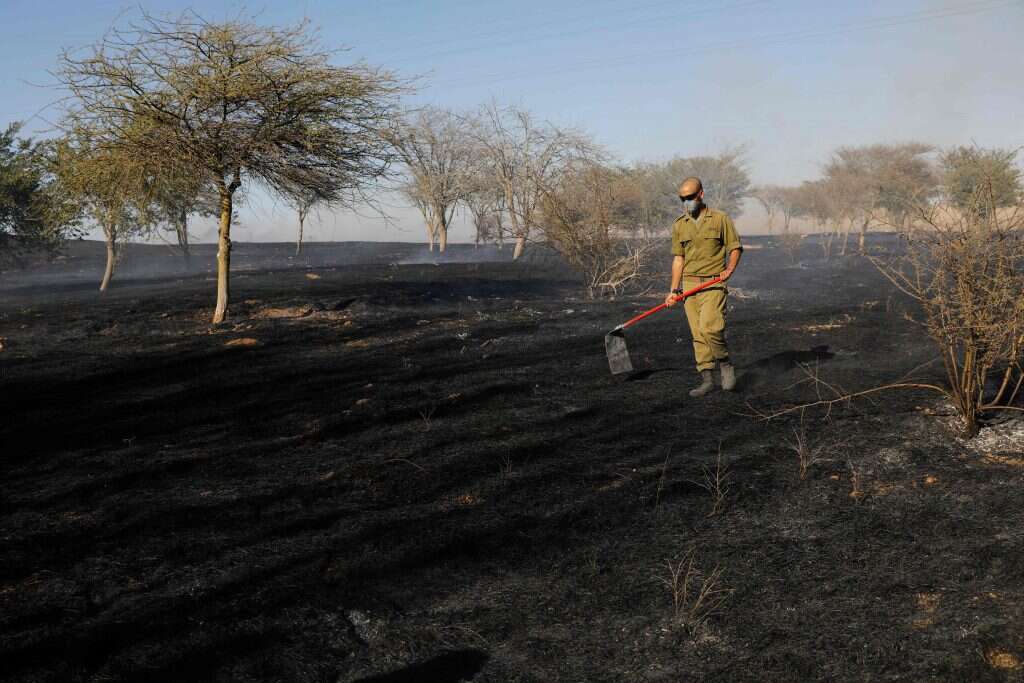 חייל מכבה שרפה בעוטף עזה. | AFP