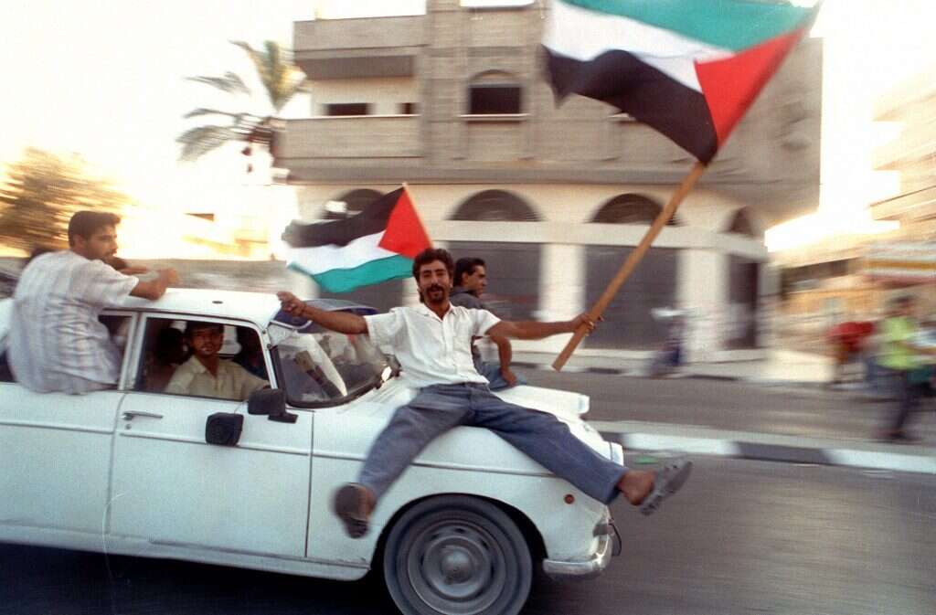 פלסטינים חוגגים עם דגלי אש''ף במכונית דוהרת בעזה ביום חתימת הסכם אוסלו בוושינגטון, 13 בספטמבר 1993. | AP