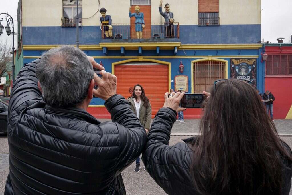 תיירים בשכונת לה-בוקה בבואנוס איירס. | AFP תיירים בשכונת לה-בוקה בבואנוס איירס. | AFP