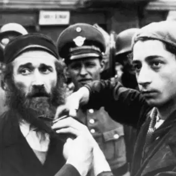 חיילים נאצים מאלצים יהודים לחתוך את זקנם. | גטי אימג'ס