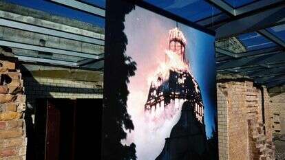 תמונה של בית כנסת עולה בלהבות. מוצגת בתערוכה במוזיאון בברלין. | AFP