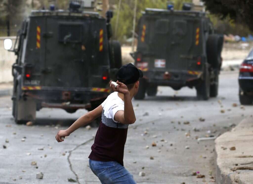 ילד פלסטיני רוגם באבנים  רכבים של צה"ל. | AFP