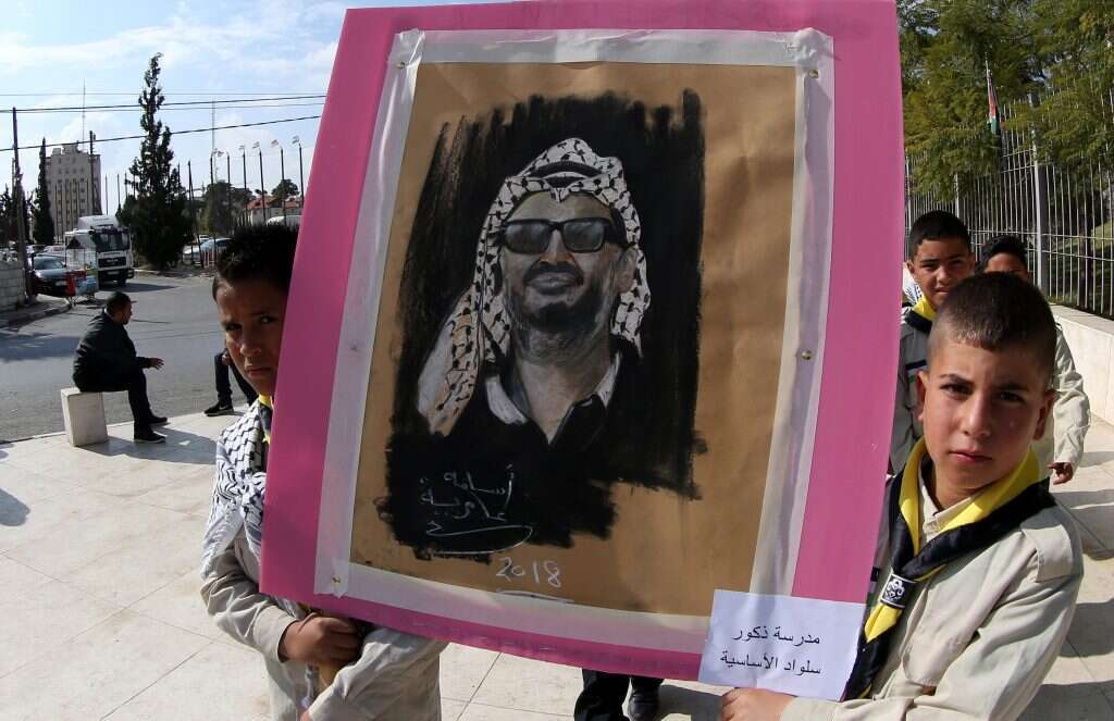 ילדים פלסטינים מניפים שלט לזכרו של יאסר ערפאת. | EPA