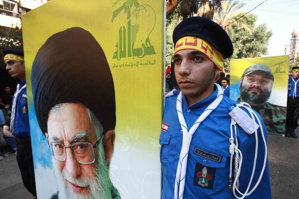 תומך חיזבאללה מניף שלט עם דמותו של המנהיג העליון באיראן עלי חמינאי. | AFP