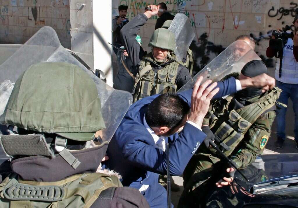 כוחות הביטחון של הרשות הפלסטינית מכים תומך חמאס. | AFP כוחות הביטחון של הרשות הפלסטינית מכים תומך חמאס. | AFP