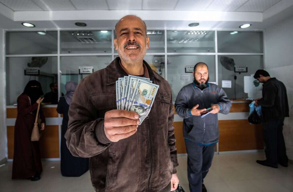 תושב עזה אוחז בכסף הקטארי שהועבר לחמאס. | AFP