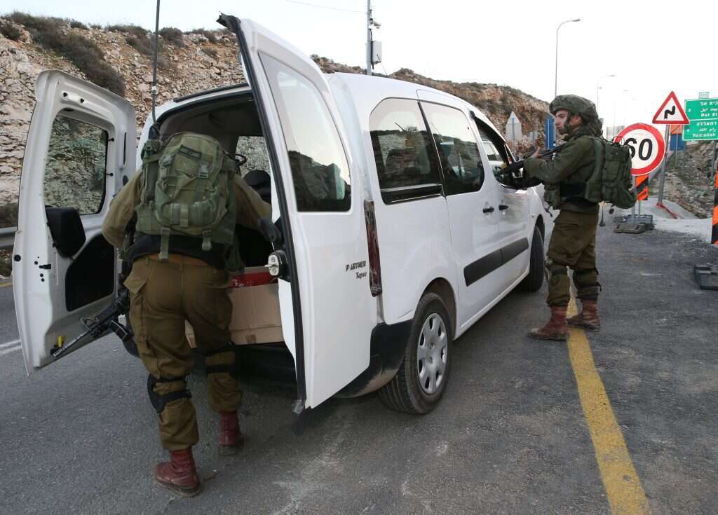 חיילי צה"ל בודקים רכב פלסטיני בטרמפיאדה ביו"ש. | מרים צחי