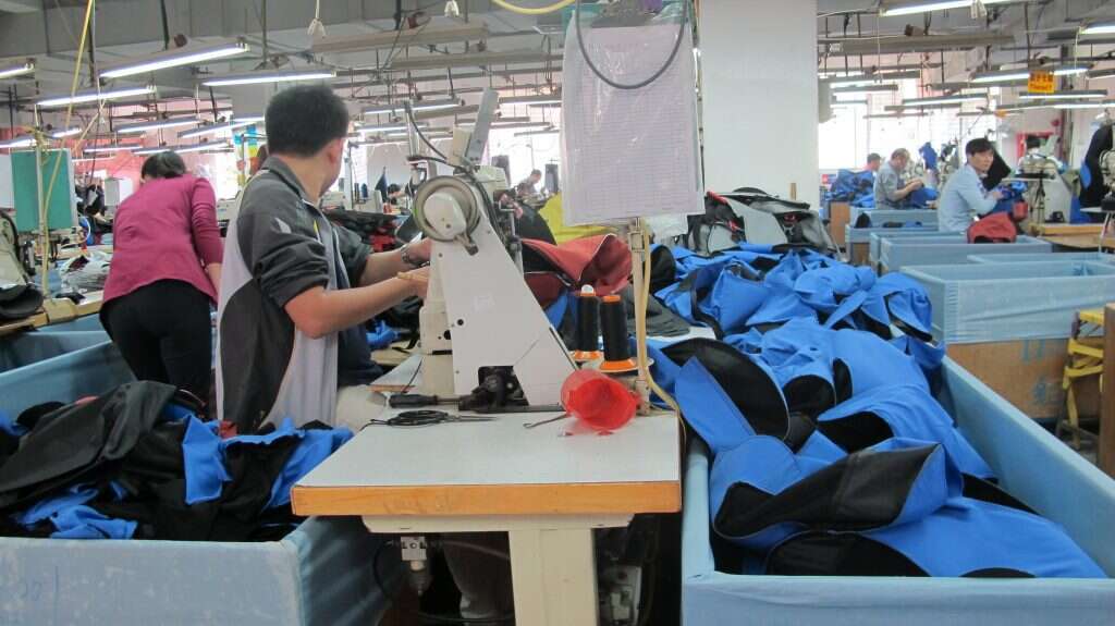 על רצפת הייצור נמצאים אנשים, לא רובוטים. ייצור התיקים בסין. | יח"צ