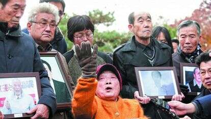 עובדת כפייה לשעבר במיצובישי מפגינה מול בית המשפט. | AP