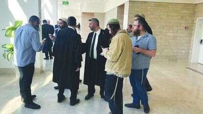 חבריהם, קרובי משפחותיהם ופרקליטיהם של החשודים בהריגת עישה א-ראבי בבית המשפט. | רויטרס