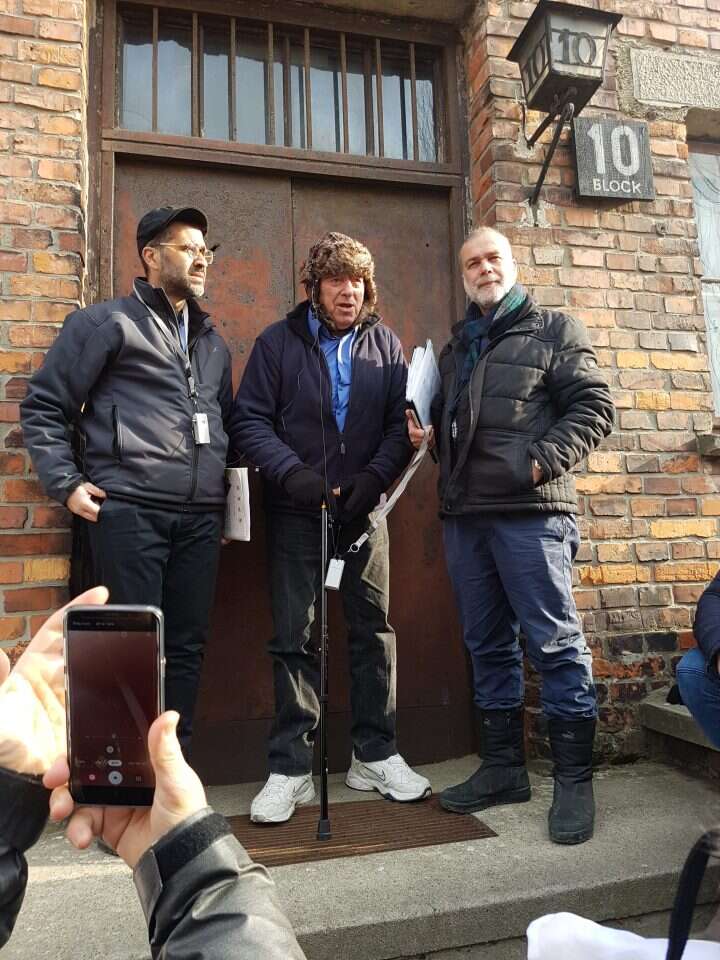 צבי ויזל נותן עדות ליד בלוק 10 באושוויץ. | רחלי מלק-בודה