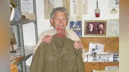 יהודה נוימן מציג את מדי השבויים במחנה הירדני במוזיאון "אוסף תש"ח" בקיבוץ עין צורים. | מתוך אוסף יהודה נוימן, באדיבות המשפחה