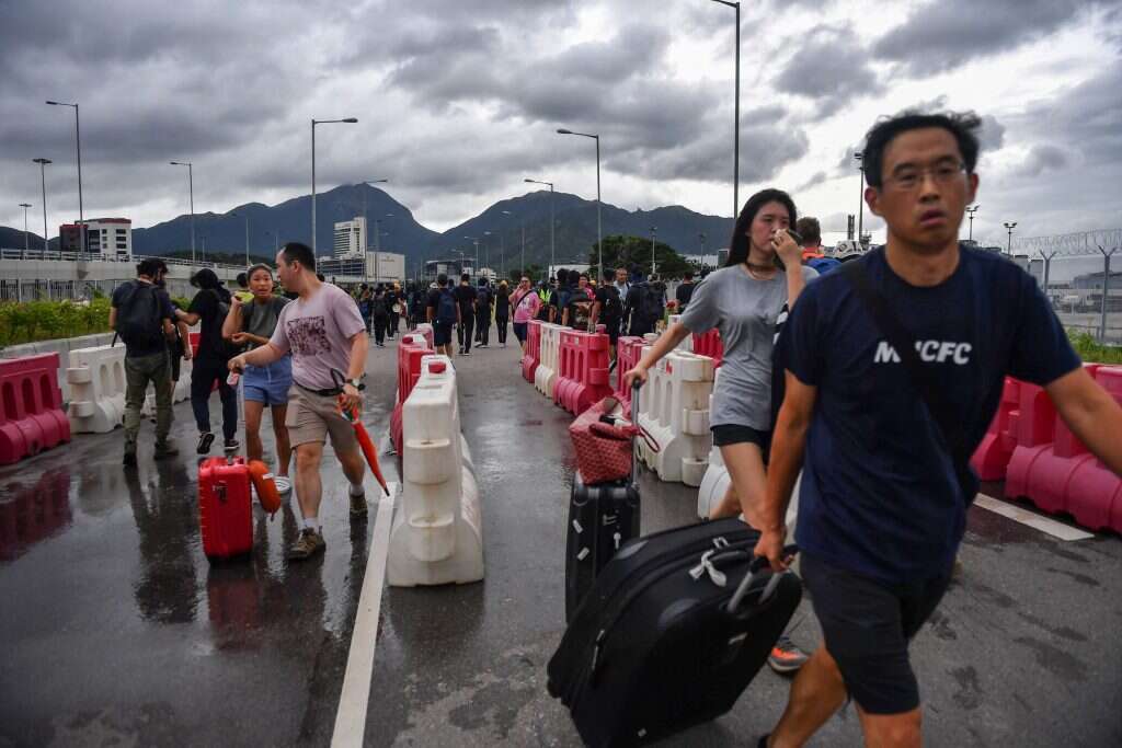 נוסעים בשדה התעופה המושבת של הונג־קונג, באוגוסט. | EPA נוסעים בשדה התעופה המושבת של הונג־קונג, באוגוסט. | EPA