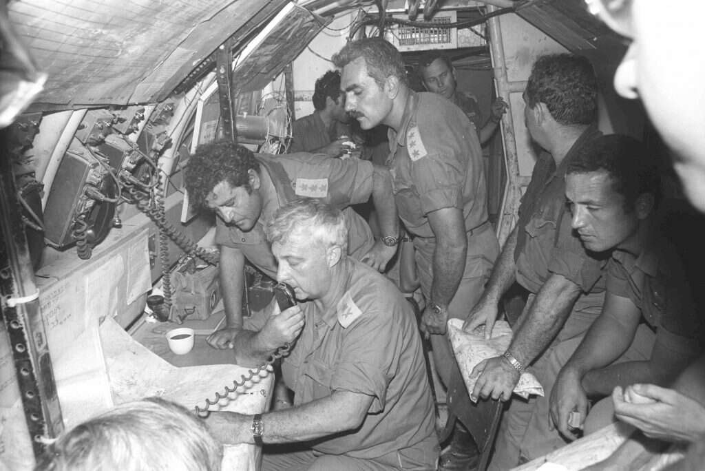 בתוך התעוז ששימש כמפקדה של המח"ט אריאל שרון. עומד מימין: אל"מ יהושע שגיא, אלוף אריאל שרון. מעליו, רוכן- אל"מ יעקב עקנין, לימינו ומאחורי מפקד האוגדה - אל״מ יהושע שגיא. אוקטובר 1973. | אלי חן. באדיבות ארכיון צה״ל במשרד הביטחון