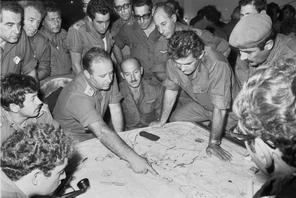 הרמטכ"ל בהתייעצות בפיקוד הצפון. מימין לשמאל: רס"ן גדי זוהר, ממושקף נראה בצדודית- שליש הרמטכ"ל, תא"ל יקותיאל (קותי) אדם (משופם בכומתה), הרמטכ"ל רא"ל דוד אלעזר ר' אמ"ן אלוף אלי זעירא, אלוף רחבעם זאבי במשקפיים כהים, אלוף מרדכי הוד, אלוף יצחק (חקה) חופי. אוקטובר 1973. | דובר צה"ל. באדיבות ארכיון צה״ל במשרד הביטחון