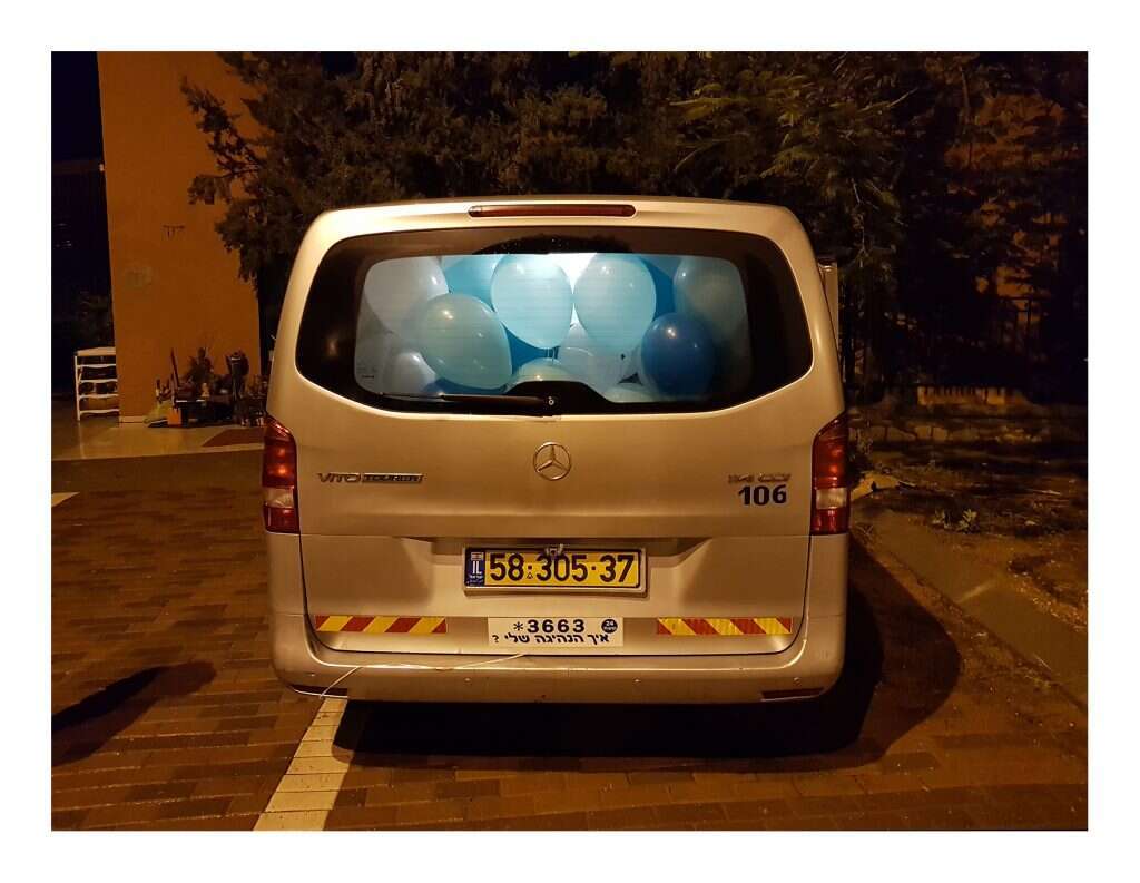 בלוני מסיבת בת מצווה משפחתית כלואים בתוך הרכב המסחרי. מתוך התערוכה "על בלי־מה" של שרה מוכתר