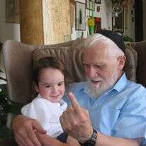 תחושת הפליאה מולו רק
תלך ותתעצם עם השנים.
הרב דוד פוקס עם אחד
מילדי משפחת ברוש,
תשס"ז. | אסף ברוש