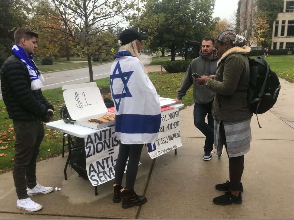 לתהליכים שמתרחשים במוסד האקדמי יש השפעה שחורגת מעבר לקמפוס. הדוכן באוניברסיטת המדינה מישיגן. | אריאל שנבל