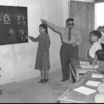 נחמד יותר לאנגלז את העברית מאשר לתַנֵך אותה. תלמידים מעולי איטליה ומרוקו במושב עלמה בגליל, 1950. | פריץ כהן - לע"מ